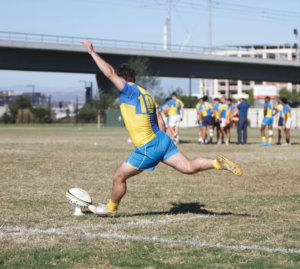 Rugby team player kicking the ball