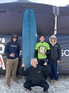 Team standing in front of surf board 