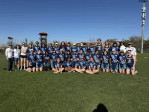 People in sports uniforms grouped together on field