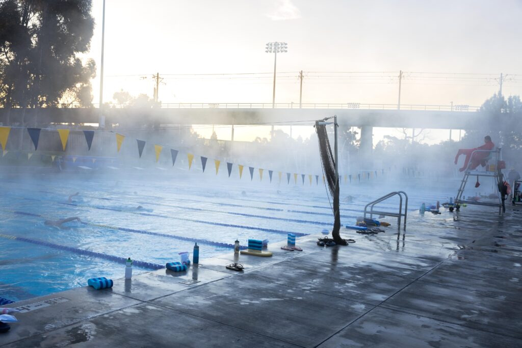 A steam covered pool with swimming lanes is shown under a gray sky.
