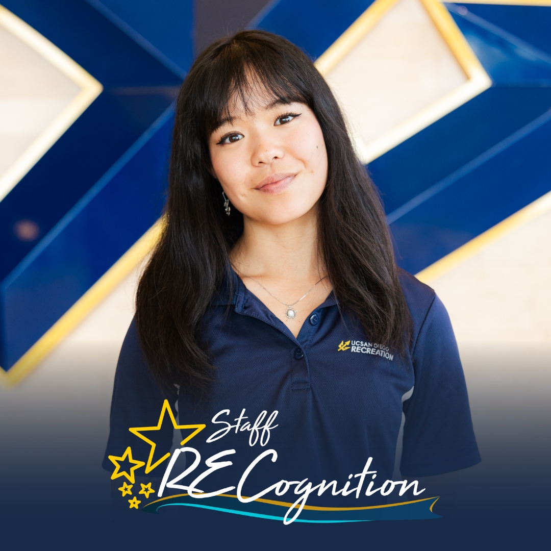 Alexis, a young adult woman with straight dark hair, stands in front of a blue trident on a wooden wall. A RECognition logo is shown at the bottom.