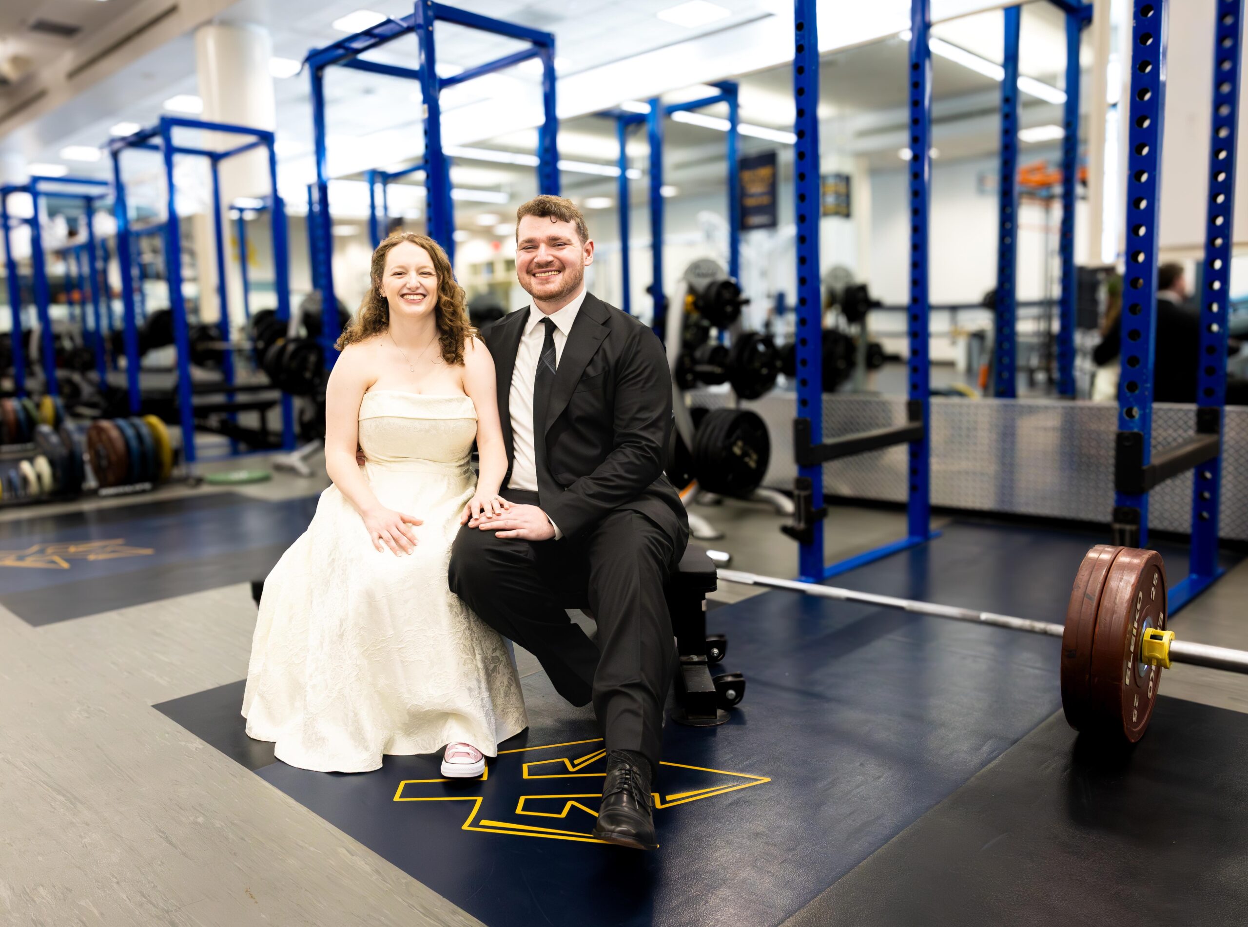 Paul and Sydney are dressed in their wedding attire as they sit here in the UCSD weight room.