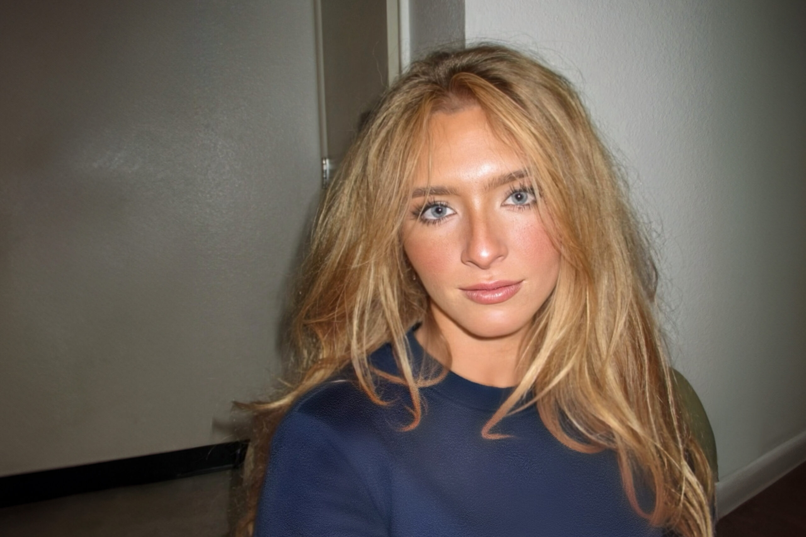 Julia Fitzpatrick is a young woman with blonde hair. She wears a blue crewneck shirt.